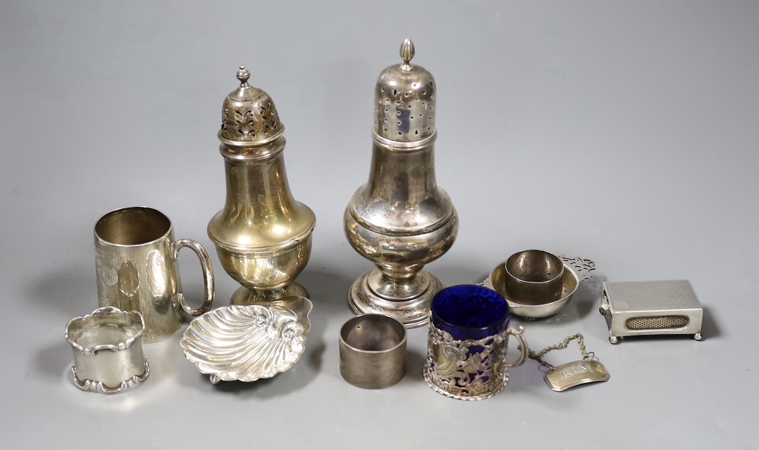 Sundry small silver including two sugar casters, tallest Chester, 1922, 21cm, two mugs, match sleeve, quaich, wine label and three napkin rings